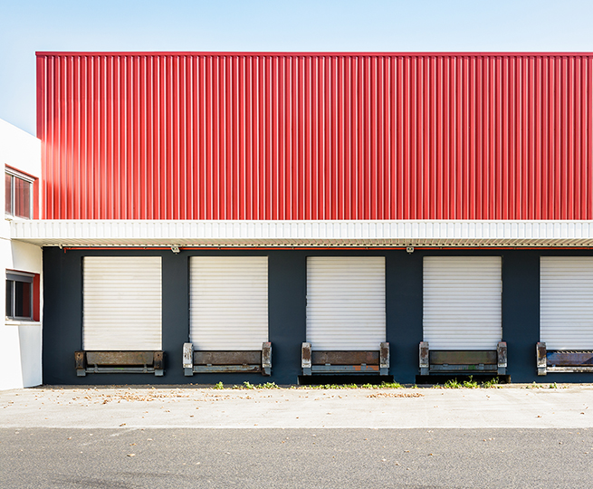 Front view of truck loading docks at a warehouse in the suburbs of Paris, France.